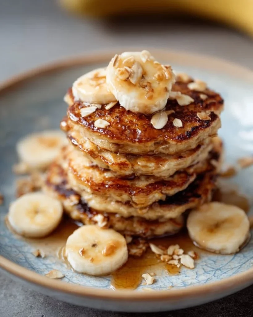Healthy banana oatmeal pancakes served with fresh fruit and syrup