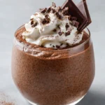 High protein chocolate chia seed pudding in a bowl with toppings.